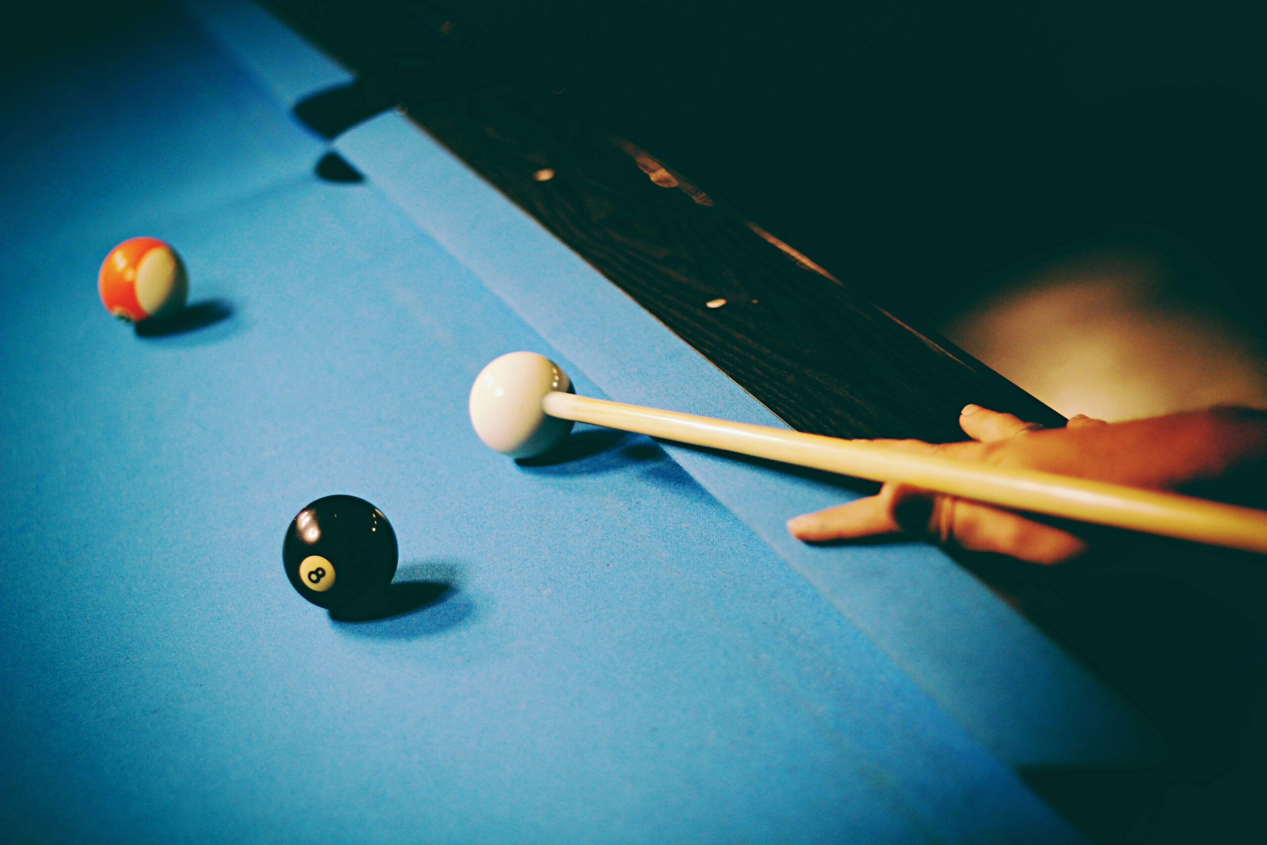 Pool table and a person preparing to shoot a shot.